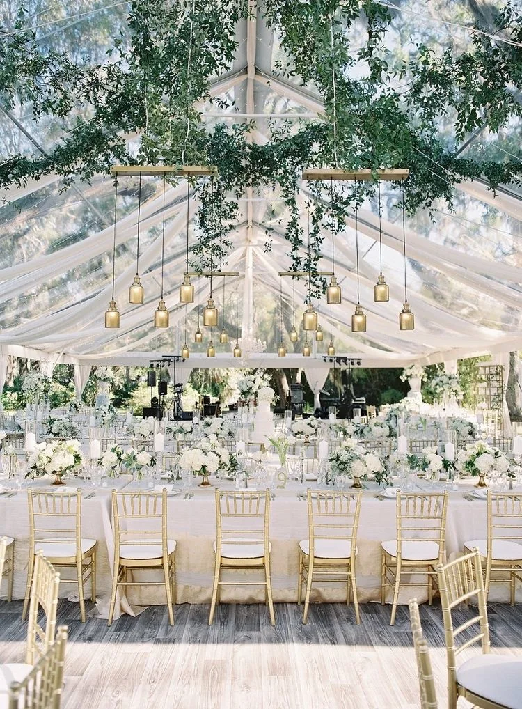 Elegant wedding reception with hanging greenery and chandeliers