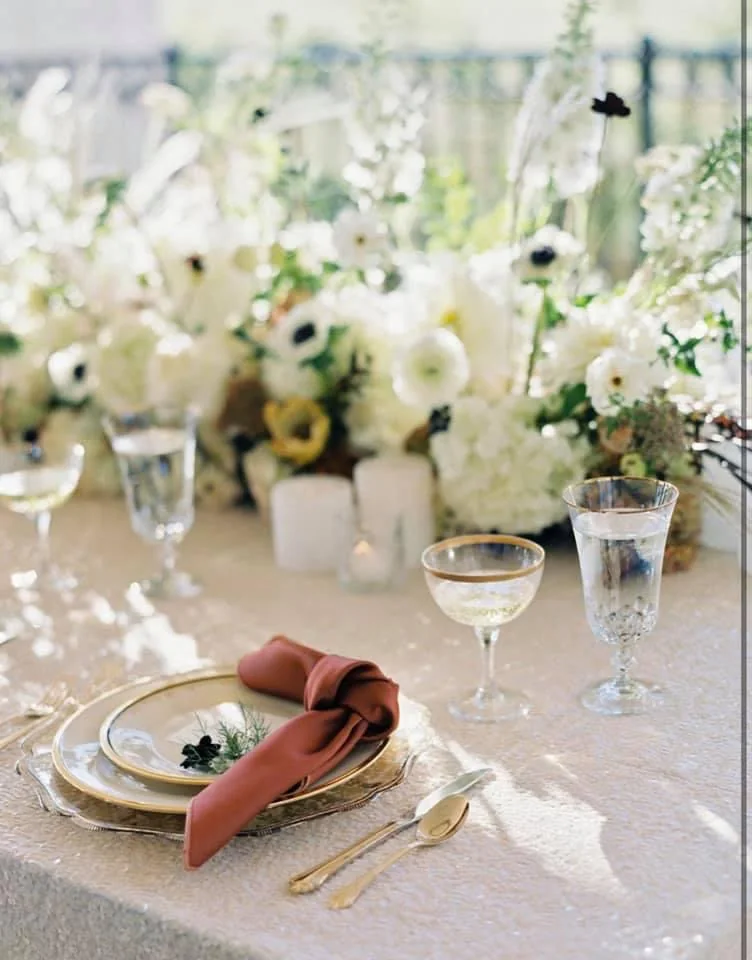Soft romantic wedding place setting with flowers and glassware